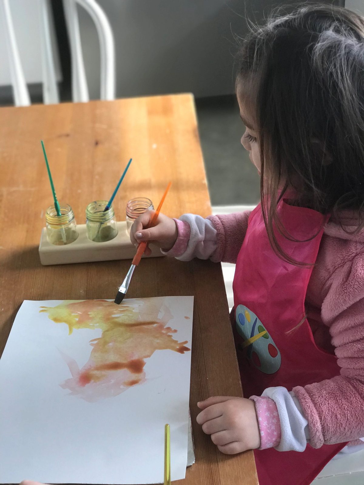 A child using watercolor paints at the table