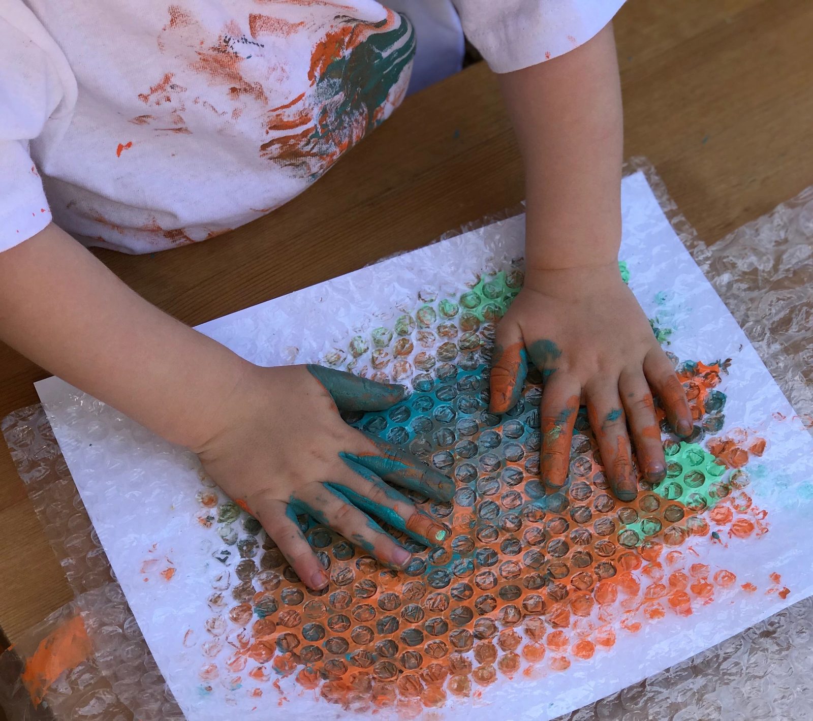 A child finger painting on a large canvas