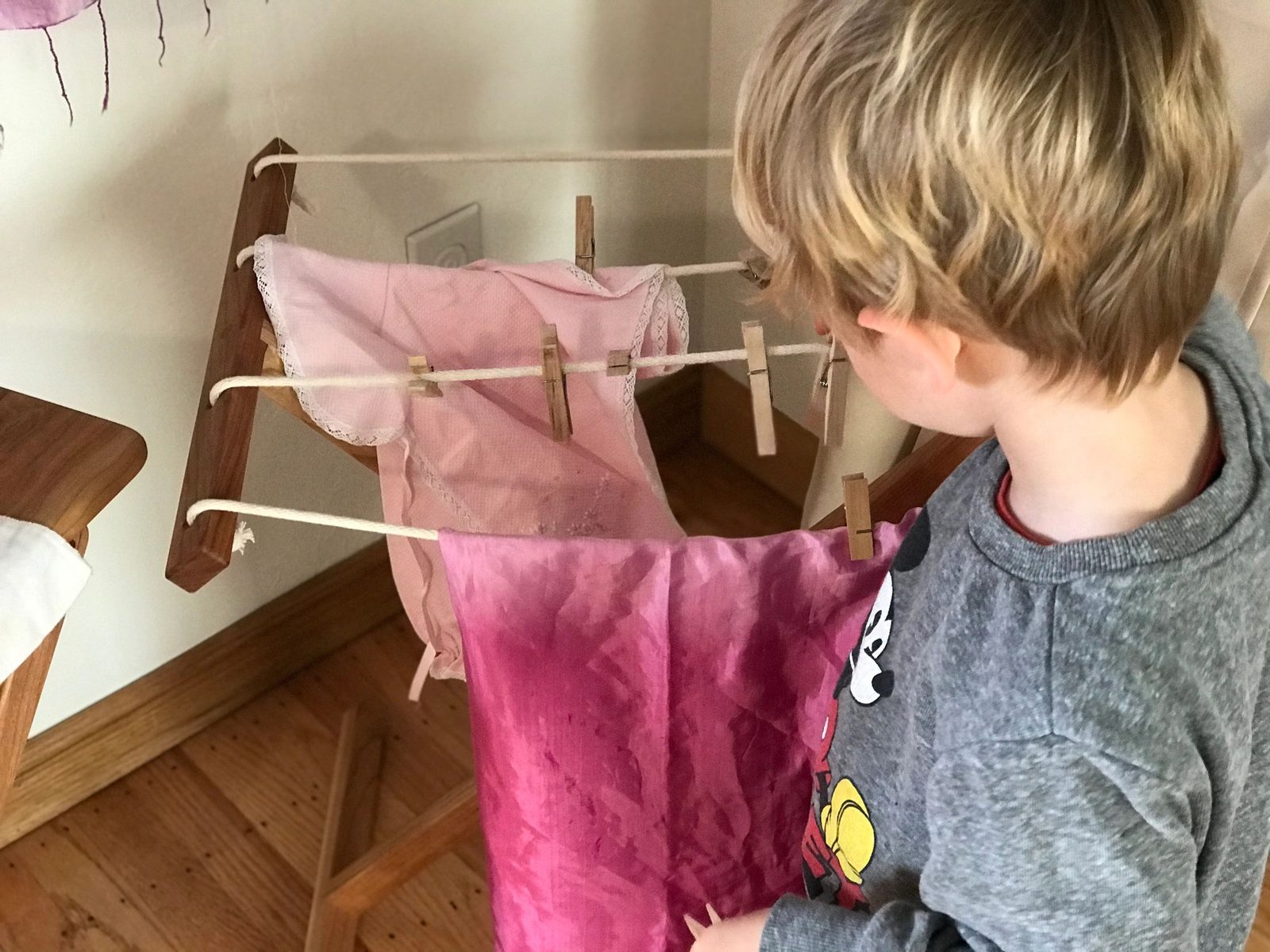 A child helping hang laundry to dry