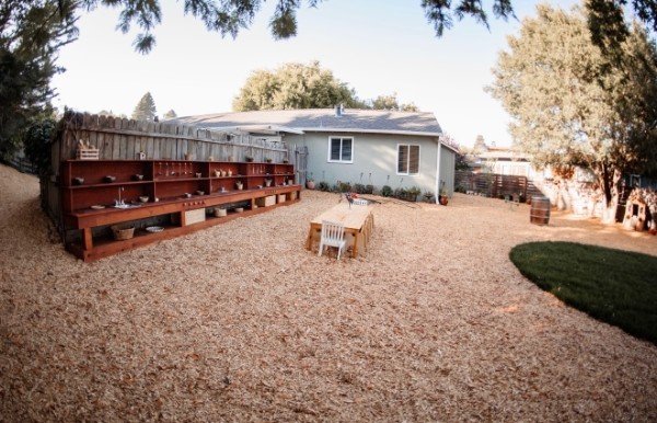 The outdoor mud kitchen shelf and a child-sized table in the yard