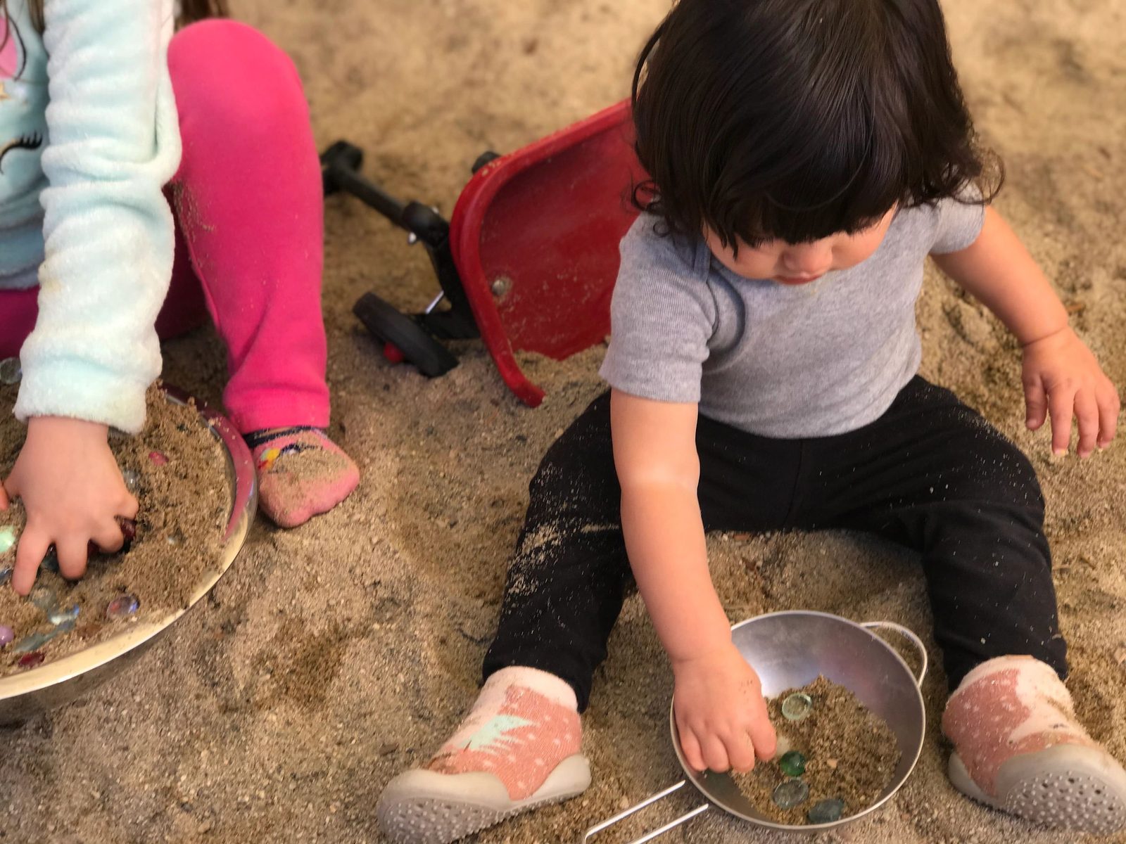 Children playing with sand and mud in bowls