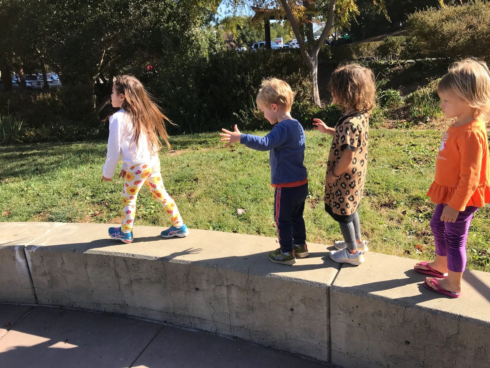 Children walking together along a garden path