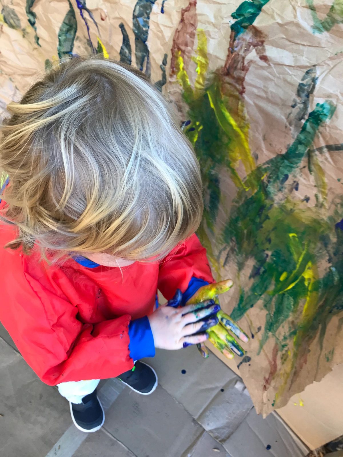 A child painting at a window easel