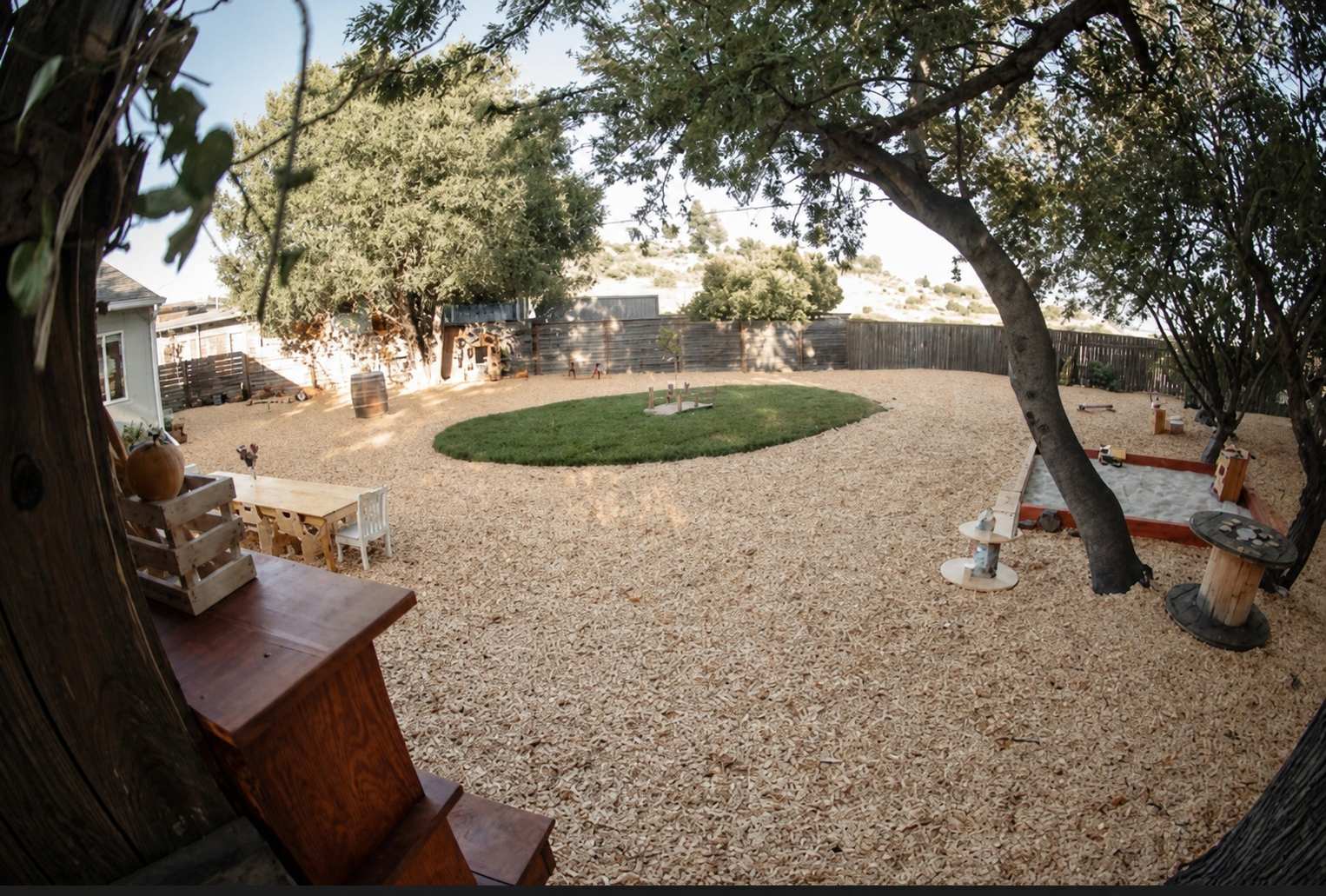 The wood-chip play yard with a grass circle and natural play areas