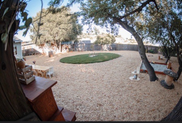 The wood-chip play yard with a grass circle and natural play areas